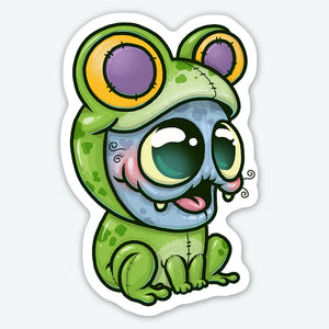A cartoon sticker of an adorable, wide-eyed green frog with big yellow and purple eyes and a playful, whimsical expression. This is a Bindlewood Shop Frog Suit matte vinyl sticker.