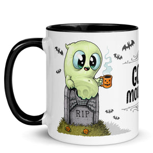 A cute green ghost cartoon character by Chris Ryniak, sitting on a tombstone with "rip" engraving, holding a small orange cup with a ghostly design, on a Good Mourning Mug by Bindlewood Shop.