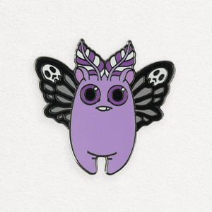 A whimsical hard enamel pin featuring a Death's Head Mothbunny Pin from Bindlewood Shop, showcasing big round eyes and feathery wings accentuated with skull motifs.