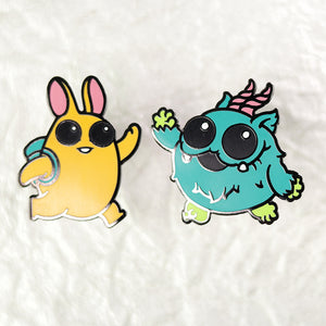 Two High Five Enamel Pin Sets on a white fluffy background from the Bindlewood Shop collection: one depicts a yellow rabbit-like character with sunglasses and a surfboard, and the other a whimsical