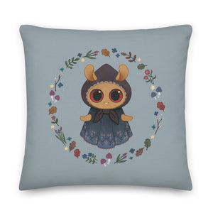 The Twilight Sprite Throw Pillow by Bindlewood Shop showcases an Amanda Louise Spayd illustration of a charming, round-eyed character in a bonnet and lacy dress. The character is encircled by a beautiful arrangement of flowers and leaves on a light grayish-blue background, making it ideal for cottagecore interior design.