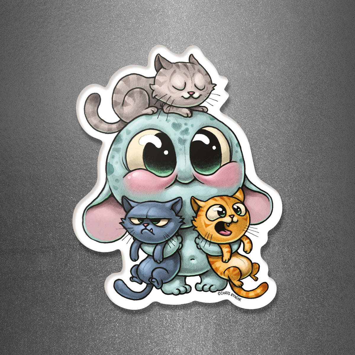 The All the Cats! Magnet from Bindlewood Shop features an adorable cartoon creature with big eyes and blushing cheeks, surrounded by three cats—a gray one perched on its head, a grumpy blue cat in its lap, and a surprised orange kitty beside it—all set against a shiny gray background for the perfect cat-inspired magnet design.