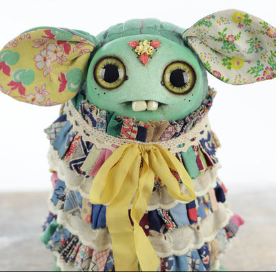 Colorful creature with floral ears and a patterned outfit on a white background
