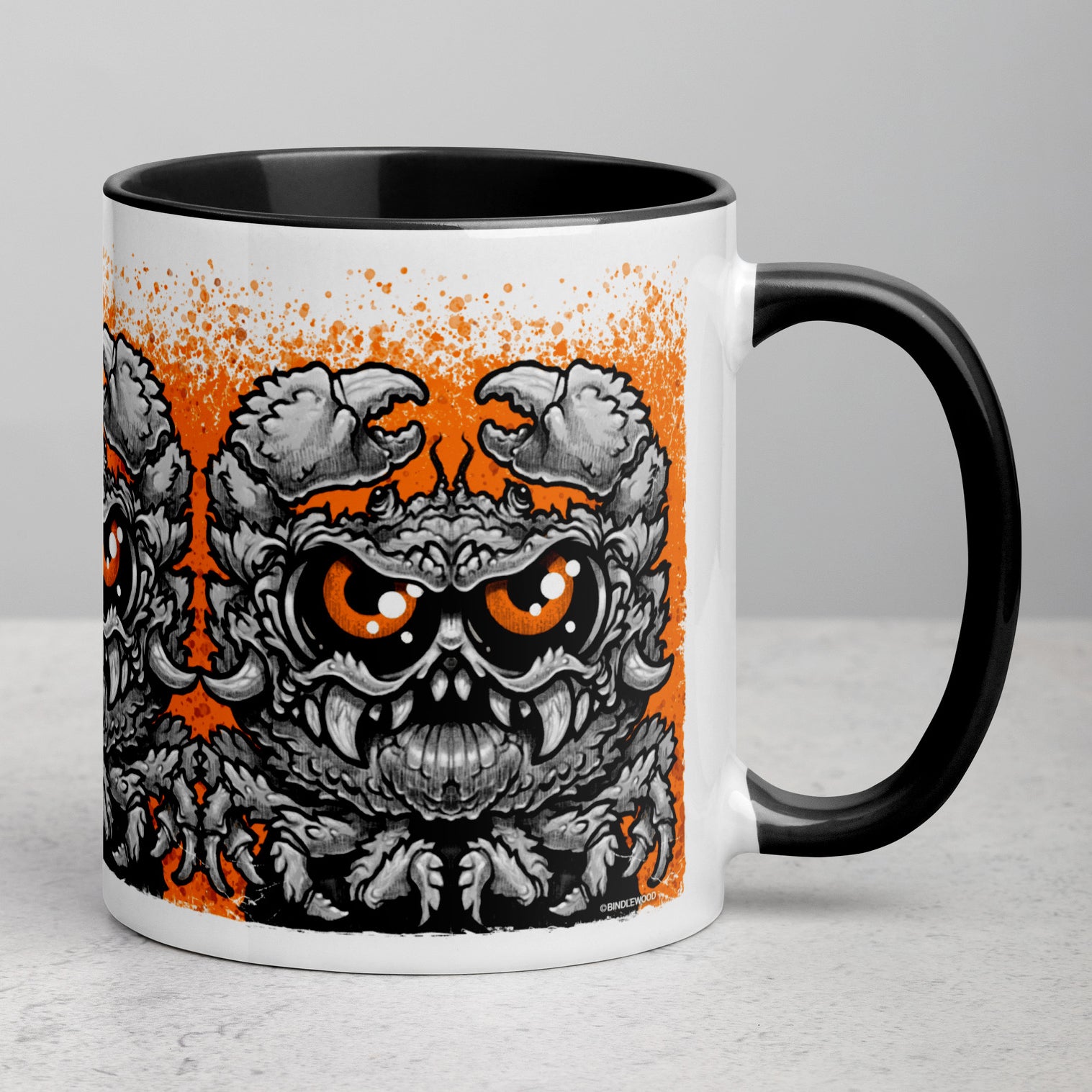 The Krabb Mug by Bindlewood Shop is a white ceramic mug with a black handle, showcasing a detailed, angry crab monster illustration inspired by Chris Ryniak in striking black and orange hues against an orange splatter background—an ideal addition to any monster mug collection.