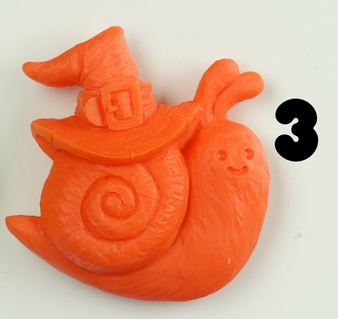 A hand-sculpted orange snail Halloween Magnet from Bindlewood Shop, wearing a witch hat and smiling beside a bold black number 3 on a white background.