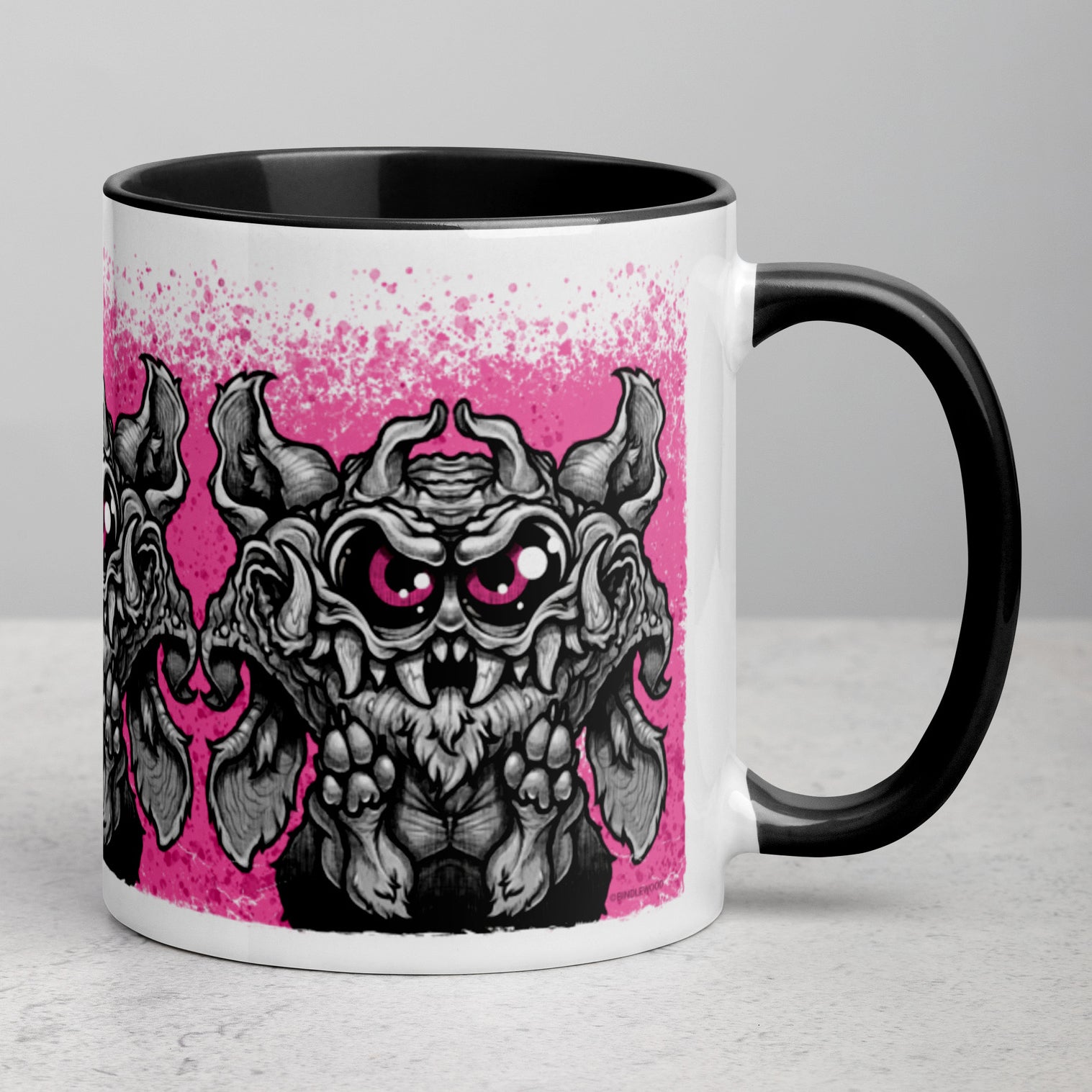 The Radbit Mug by Bindlewood Shop is a white ceramic mug with a black handle, showcasing a cartoon-style, wide-eyed Chris Ryniak monster with large ears and fangs, outlined in black against a vibrant pink splatter background. This colorful printed ceramic mug is perfect for adding a playful touch to your daily routine.