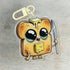 The Toastboy Keychain by Bindlewood Shop is a cute acrylic charm of a smiling toast slice with shiny eyes, melting butter, a little knife, and playful cartoon arms and legs—perfect for adding whimsy to your keys.