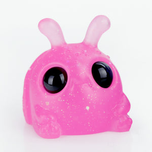 The Neon Glitterberry Weebeetle by Chris Ryniak is a cute, round, pink toy creature featuring large black eyes, two antennae, and a dot-speckled body like glitter. It sits on a plain white background.