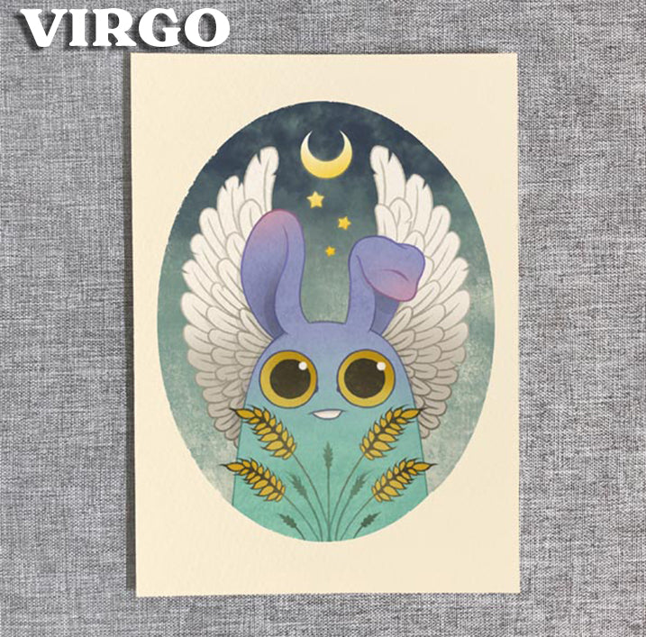 The "Virgo" print from Zodiac Prints by Amanda Louise Spayd (Bindlewood Shop) features a cute blue creature with bunny ears and angel wings, surrounded by wheat under a moon and stars on textured gray—perfect as fine art décor.