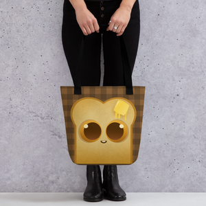 A person holds the Toast-Bag Tote by Bindlewood Shop, a durable bag with a cute cartoon bread slice (big eyes, melting butter) on a brown checkered background. The person wears black pants and boots.