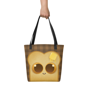 A hand holds the Toast-Bag Tote by Bindlewood Shop, a durable bag with black straps featuring a cute cartoon toast with big eyes and melting butter on its head, set on a brown checkered background.