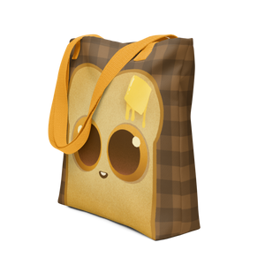 The Toast-Bag Tote from Bindlewood Shop is a brown checkered bag with yellow straps, featuring a cute cartoon bread slice with big eyes and butter—perfect for bakery runs or daily use.
