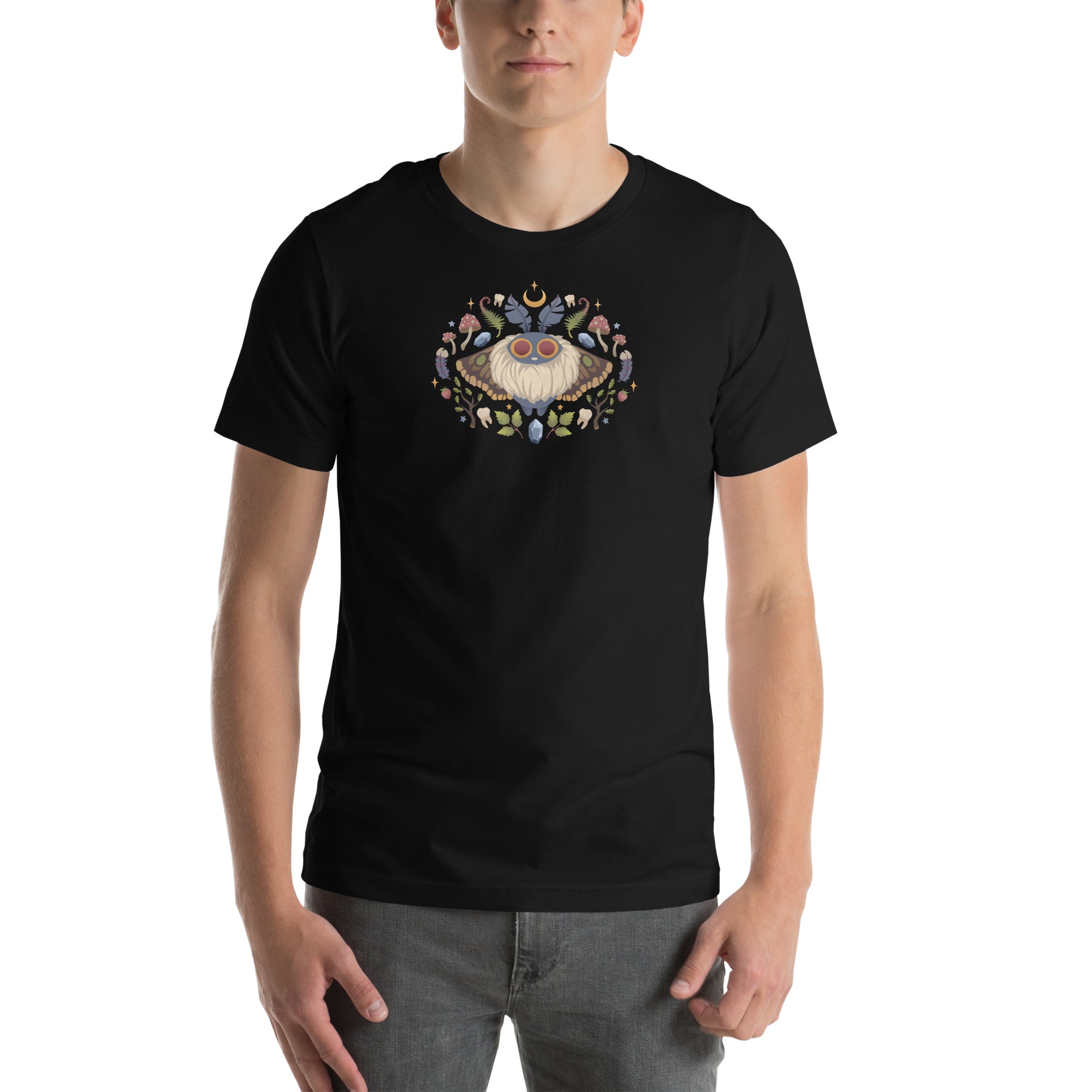 A person wearing the Bindlewood Shop Moth Magic Tee, which displays a colorful moth and floral design on the chest, stands against a plain white background.