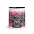The Radbit Mug from Bindlewood Shop is a white ceramic mug with a black interior, showcasing a cartoonish, wide-eyed monster in shades of gray and black, accented with pink and displayed against a playful splatter background. Inspired by Chris Ryniak’s monster designs, the mug features the initials “SMR” below the central creature.