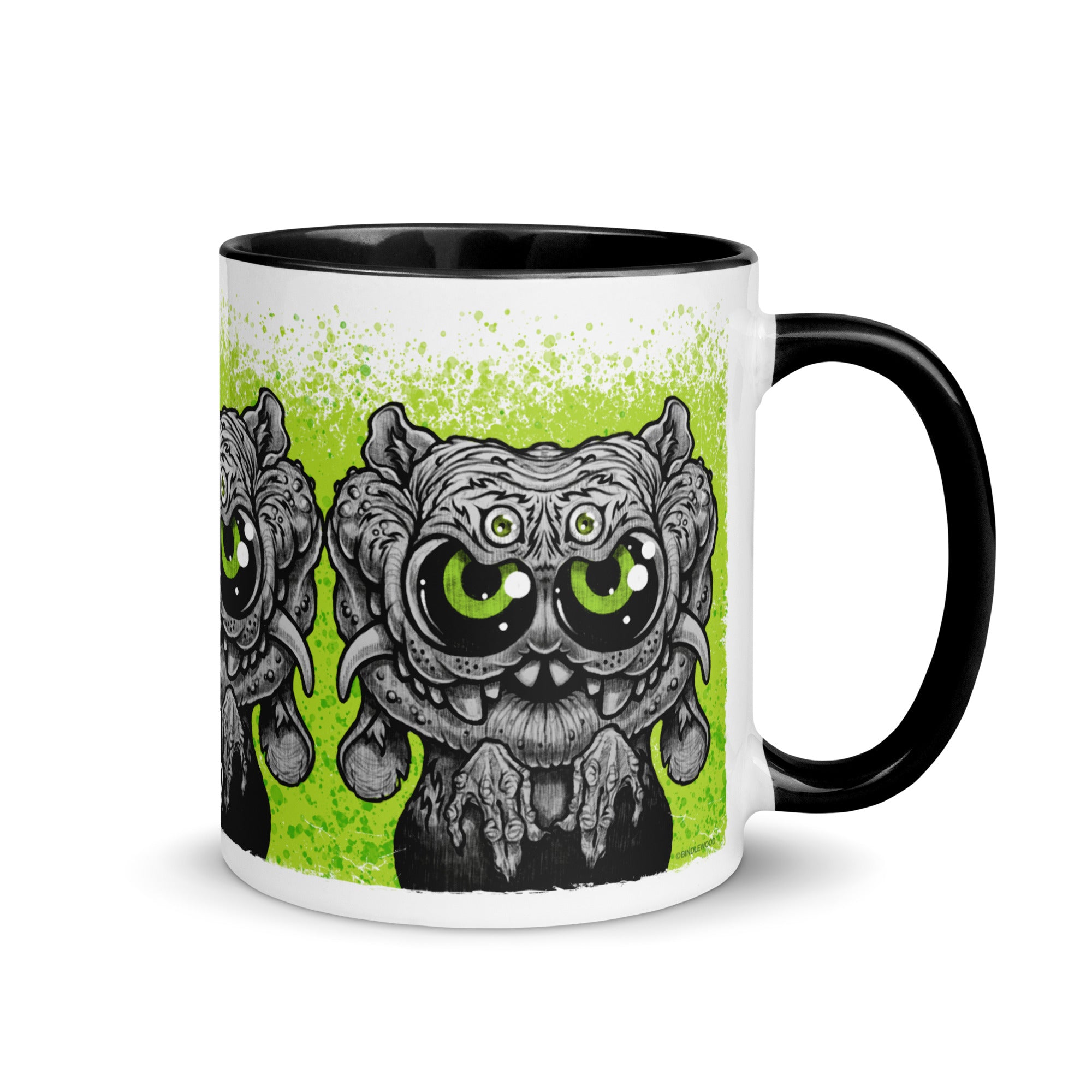 Introducing the Eyegurr Mug by Bindlewood Shop—a white ceramic mug with a black handle and rim, showcasing a cartoonish, wide-eyed alien creature with multiple eyes and fangs against a vivid green splattered background. Inspired by the playful whimsy of Chris Ryniak monster mugs, this collectible is perfect for fans of quirky and unique drinkware.