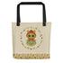The Garden Sprite Tote from Bindlewood Shop is a spacious beige bag with black handles, adorned with a charming, wide-eyed character in a hooded green outfit. The character is encircled by a floral design, and the weather-resistant fabric ensures durability. The base of the tote features a coordinated floral pattern and proudly displays the Bindlewood logo.