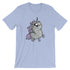 A light blue Goth Ponycorn Tee from Bindlewood Shop featuring a whimsical illustration of a chubby, wide-eyed unicorn with a purple mane and small wings. The unicorn stands upright with a happy expression, adding a playful and cute touch to the design. Made from high-quality fabric, it offers a comfortable, gender-neutral fit.