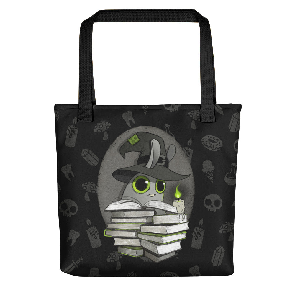 Bindlewood Shop’s Witchbunny Tote features a magical black cat in a witch hat with books and green magic, plus mystical symbols in the background—the perfect spellbook bag for essentials (and maybe Dust Bunnies). Original design.