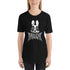 A person is wearing a Black Metal Pipsqueak Tee by Bindlewood Shop featuring a white cartoonish rabbit with wide eyes and a slightly unsettling expression. Below the rabbit, an intricate, spiky text design adds to the edgy aesthetic. The soft and lightweight T-shirt offers a comfortable, gender-neutral fit. The individual has long, straight hair and stands against a plain background.