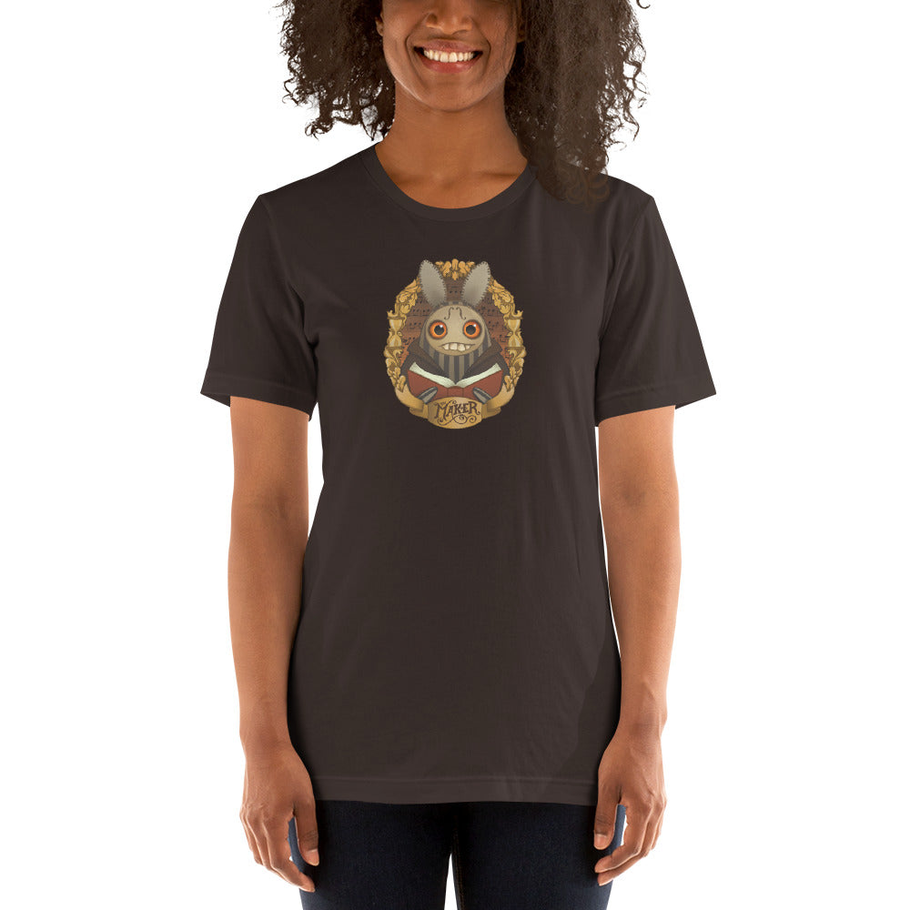 A woman smiling and wearing a dark t-shirt featuring a unique Thimblestump Hollow graphic print, designed by Chris Ryniak and Amanda Spayd, on the front. The t-shirt is "The Maker" Tee by Bindlewood Shop.