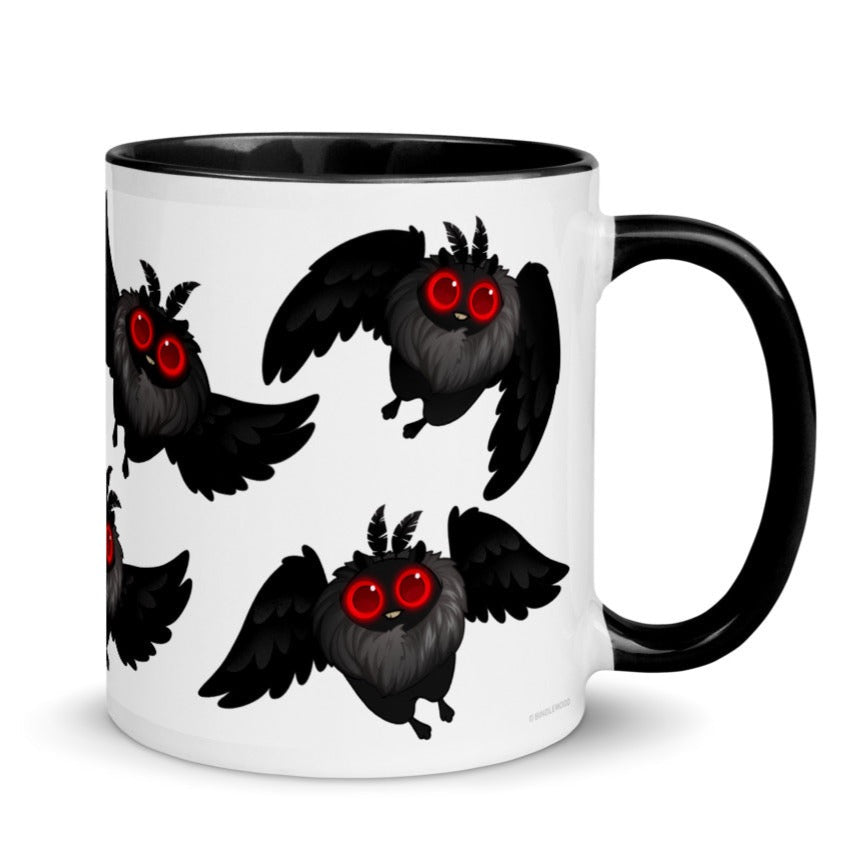 A white mug with a black handle and rim features a repeating pattern of cute, cartoonish black winged creatures with red eyes. Designed by Amanda Louise Spayd, this Mothman Cryptid Mug from Bindlewood Shop depicts the cryptozoology researcher's beloved creatures in various flying poses across the surface of the mug.