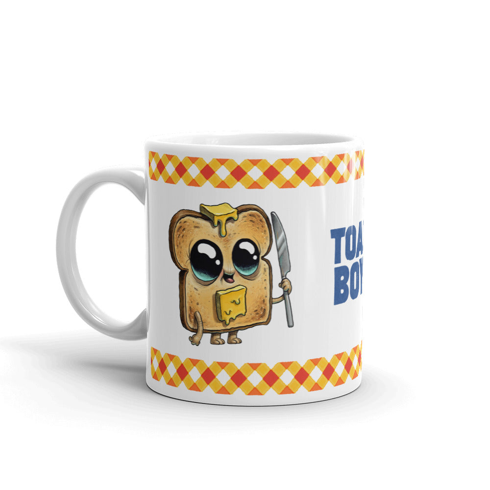 The Bindlewood Shop's Toastboy Mug showcases a delightful illustration of an adorable, anthropomorphized toast slice with butter and syrup, wielding a knife. The toast character is designed with big, shiny eyes and a cheerful expression. This glossy white ceramic mug, adorned with a patterned border and the words "Toast Boss" beside the character, is both dishwasher and microwave safe.